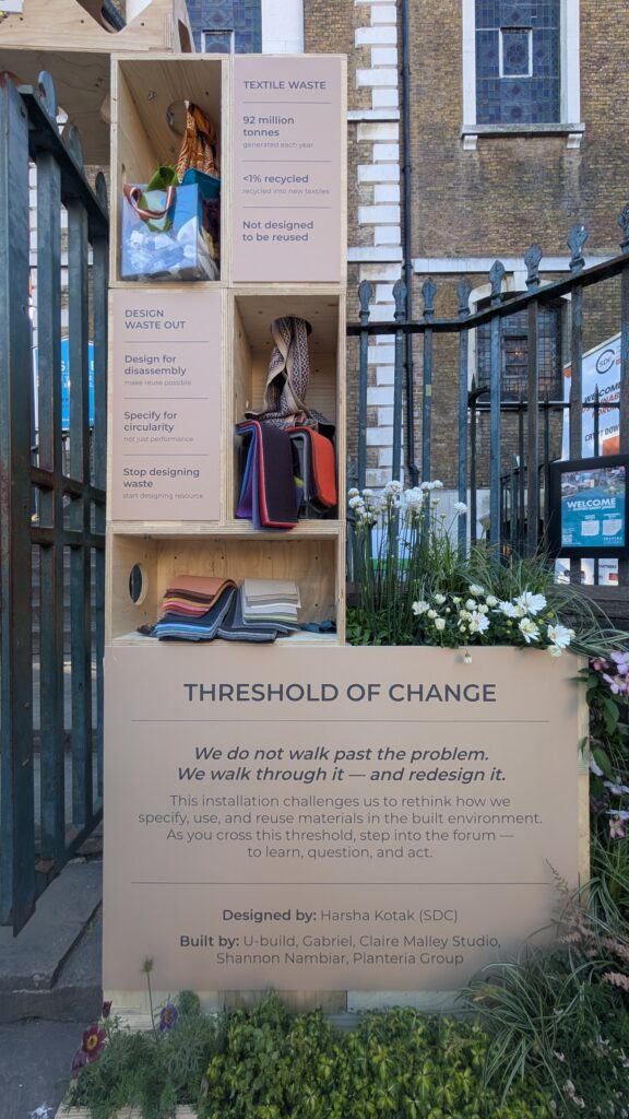 The Threshold of Change art installation showcases textile waste stats, folded fabrics, and bags, urging us to rethink materials and step through to redesign how we use resources.